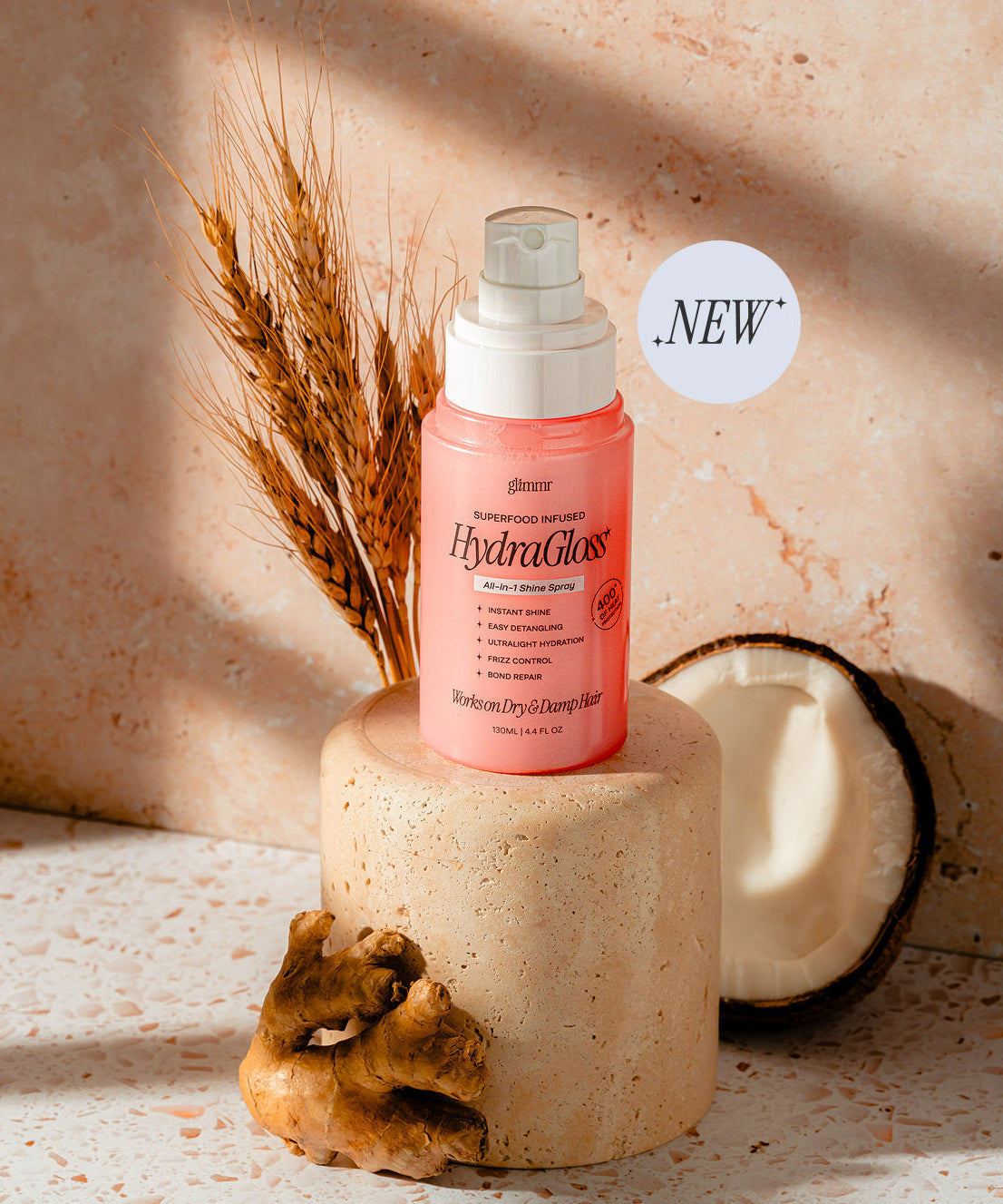 Pink bottle of 'HydraGlow' on a textured surface with natural elements